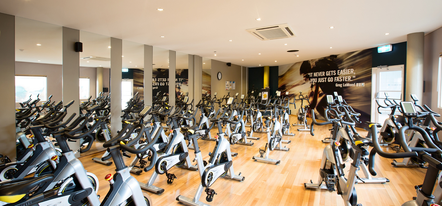 A photo of a cycle class filled with exercise bikes