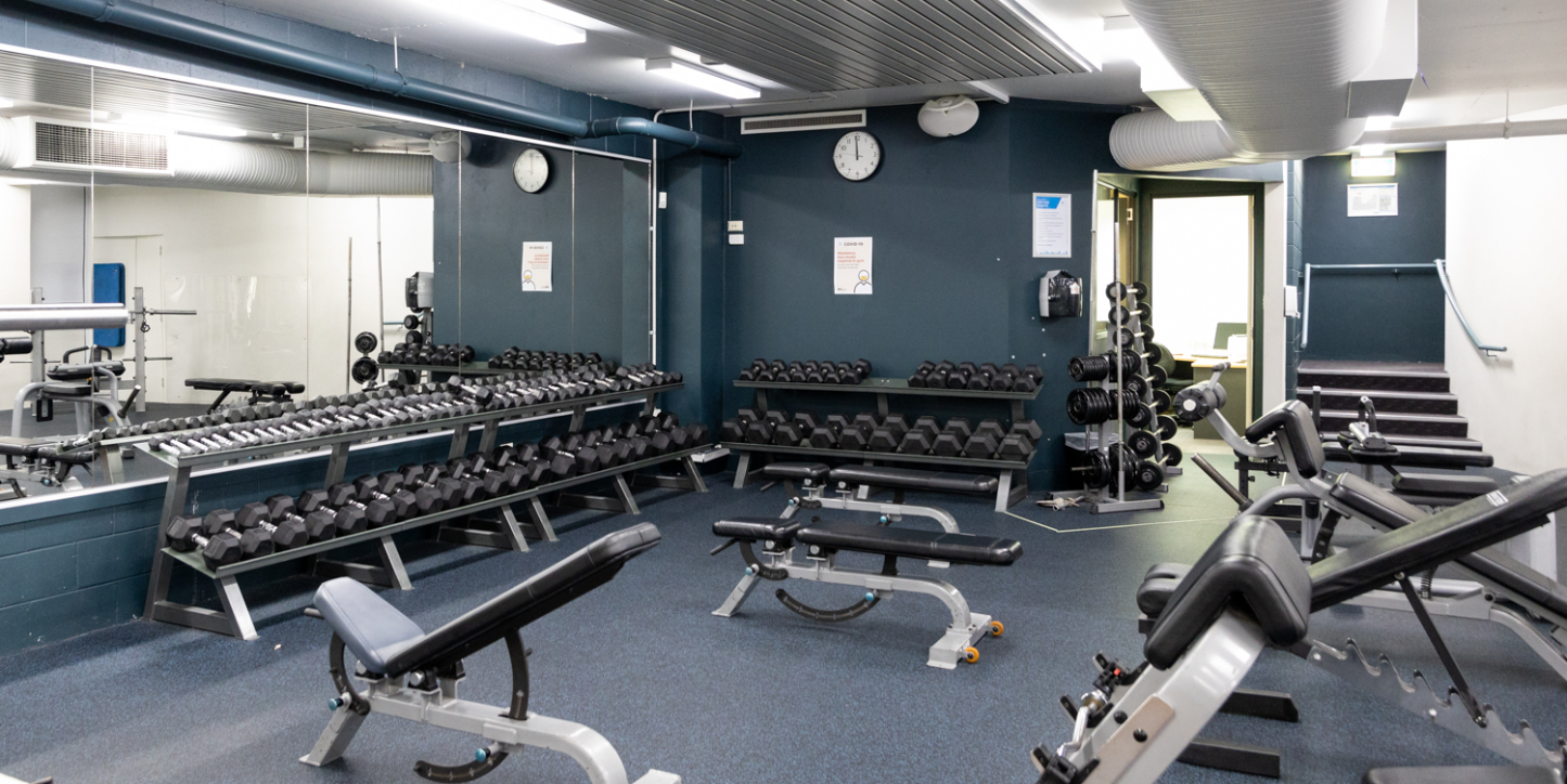 A photo of a section filled with free weights and benches