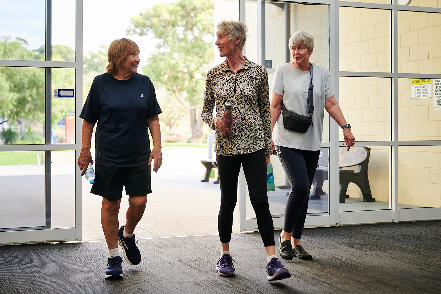 Reformer Pilates Members walking through the doors at Perth HPC whilst smiling and chatting