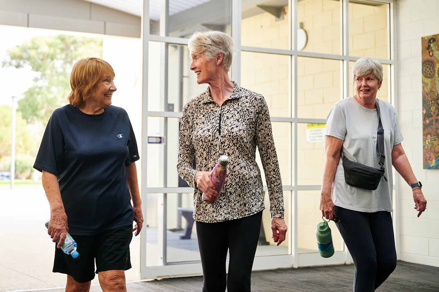 Three senior ladies laughing whilst walking into Perth HPC Reformer Pilates Studio and gym