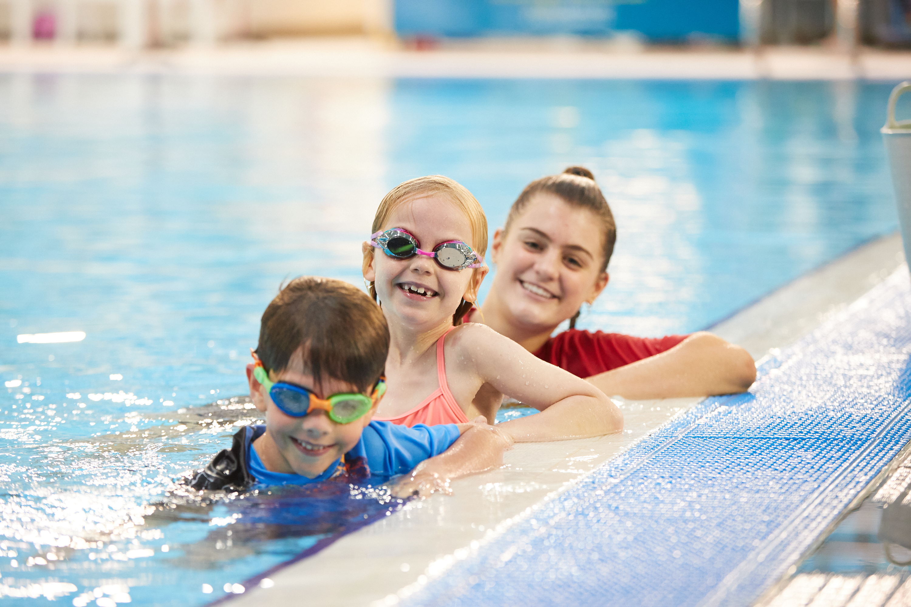 Two children and a teacher lined up in the pool at Perth HPC in Mount Claremont