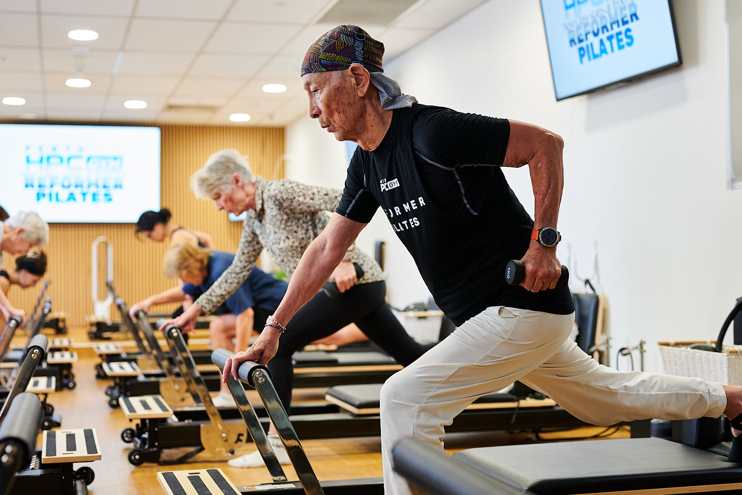 Group of people performing Reformer Pilates exercise in class at Perth HPC
