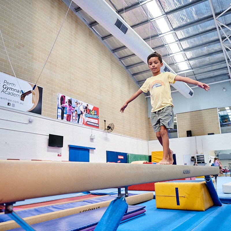 Boy walking on beam in Gymnastics facility