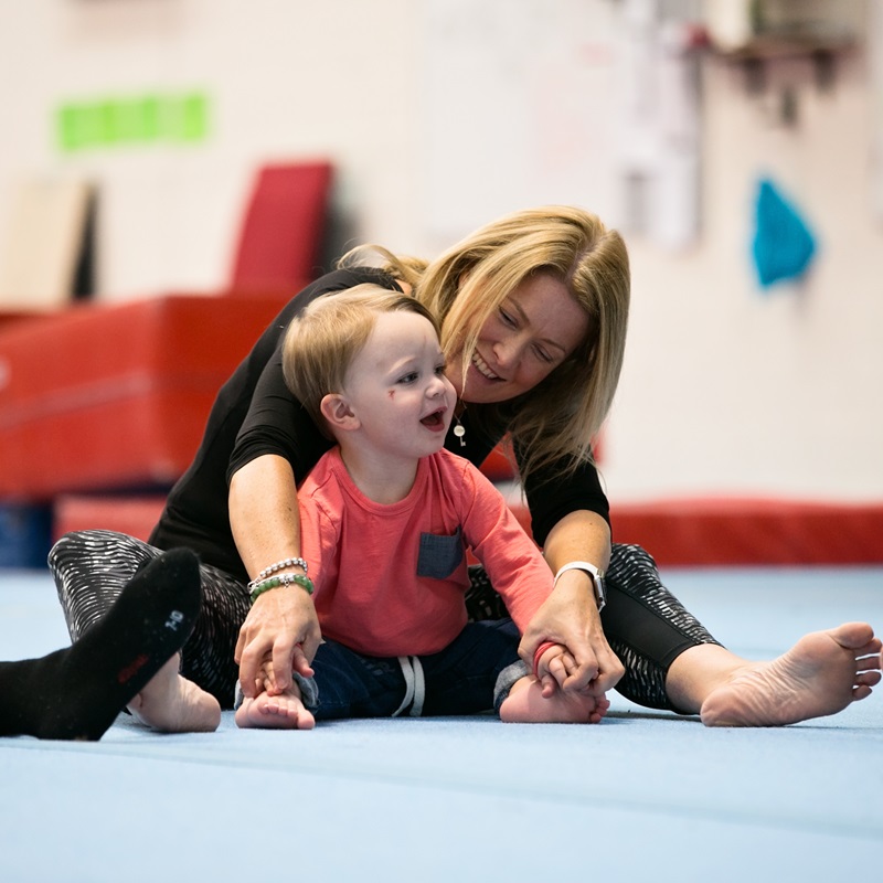 Mum and toddler sitting on the floor mat at toddler gym