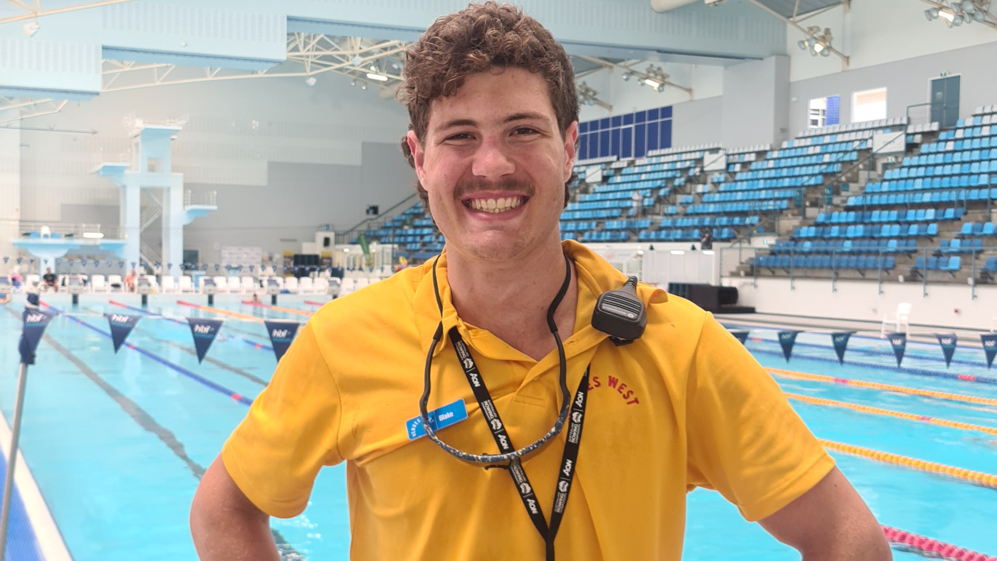 venues west worker smiling in front of the lane pool