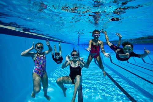 Group of happy kids swimming underwater