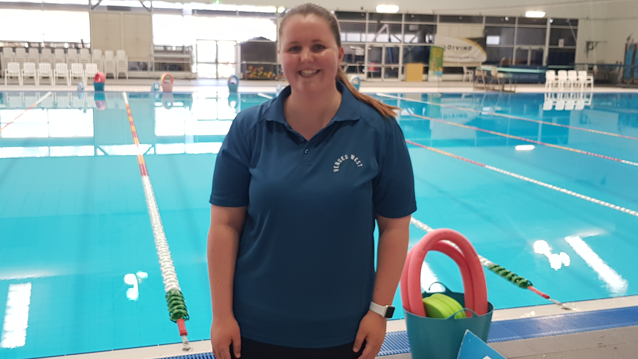 swim school team member standing in front of pool