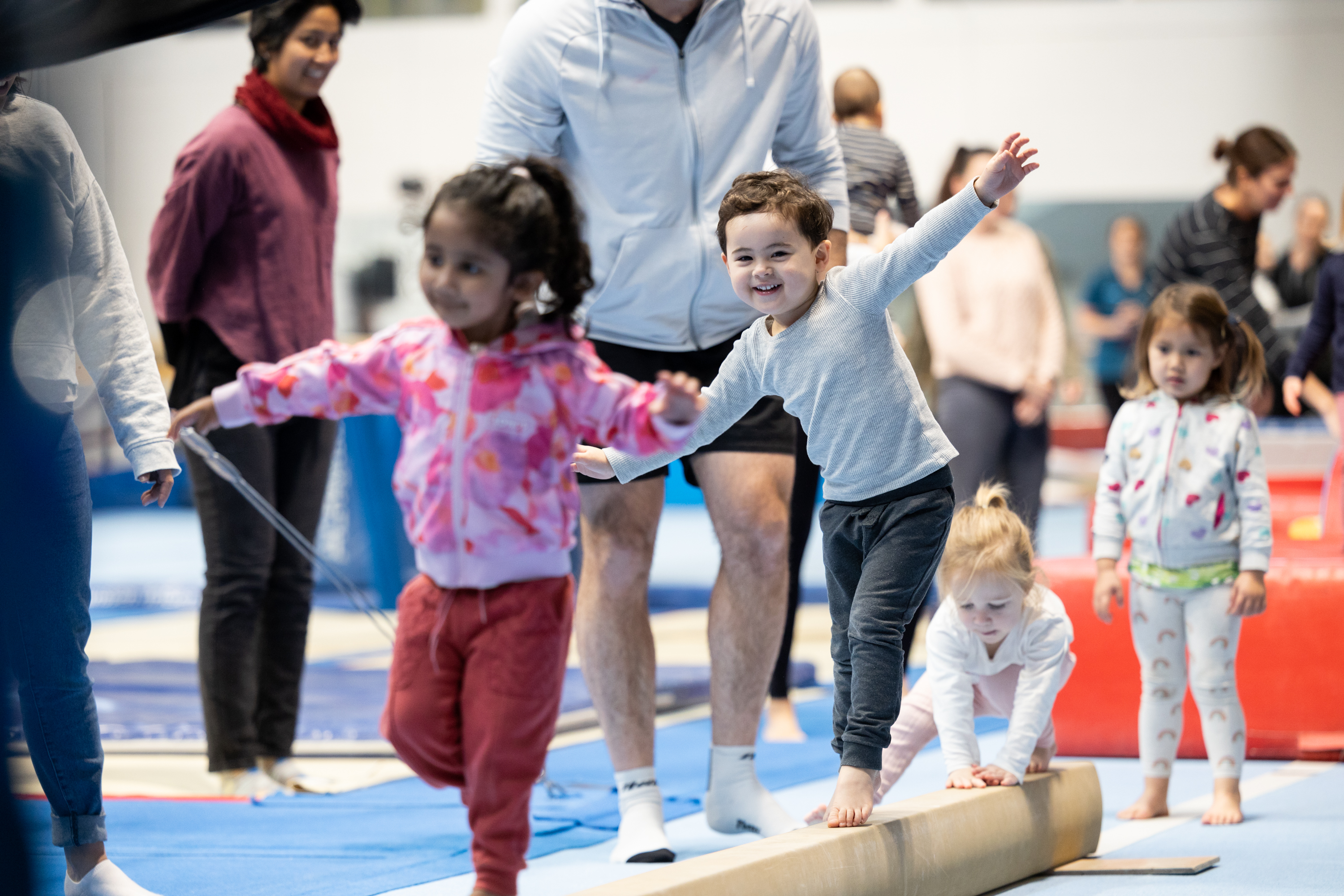A group of kids balancing as they walk along a bar on the floor at the Perth HPC Kids Gymnastics in Mount Claremont, Perth
