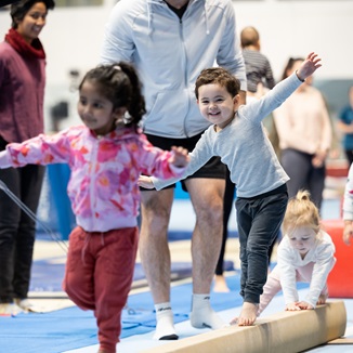 A group of kids balancing as they walk along a bar on the floor at the Perth HPC Kids Gymnastics in Mount Claremont, Perth